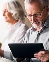 Elderly couple researching pension options online Elderly couple researching pension options online